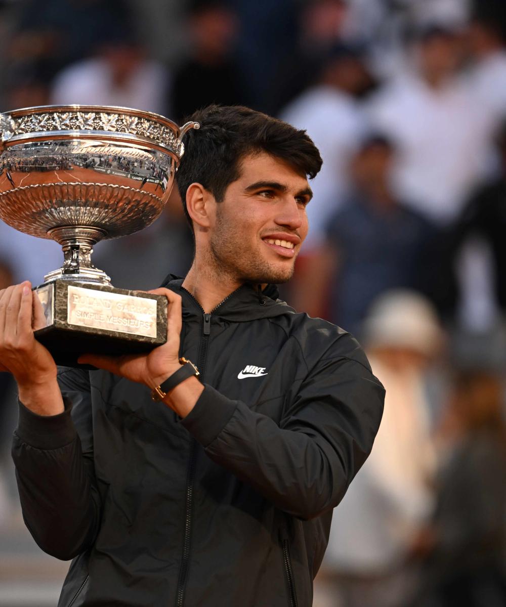 Carlos Alcaraz celebrating his victory at Roland Garros 2025, holding the trophy