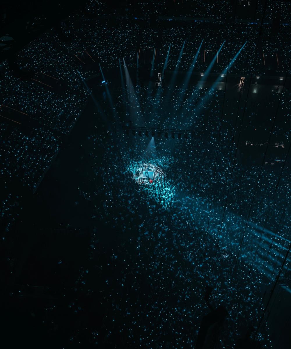 Concert VIP de Gims à la Paris La Défense Arena, avec la scène illuminée et une foule enthousiaste.