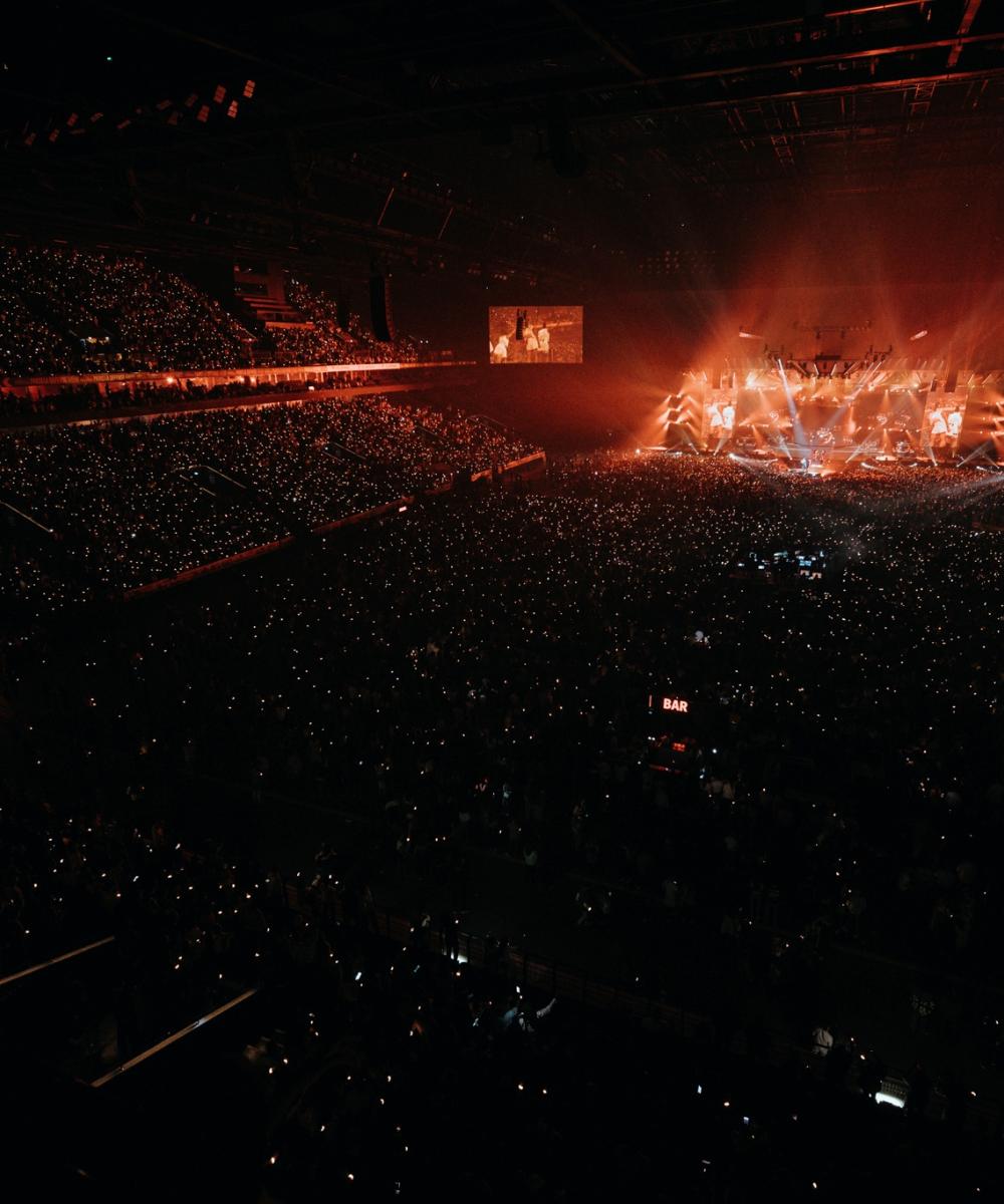 Kendrick Lamar on stage during his concert at the Paris La Défense Arena, surrounded by bright lights and an excited crowd. Book your VIP tickets with a premium view, services and experience.