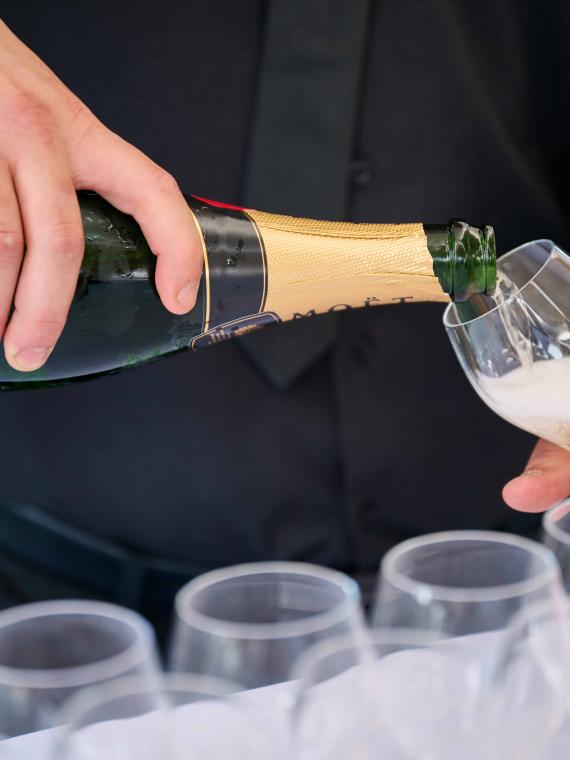 Un serveur qui sert du champagne à l'espace hospitalité VIP Salon Ferveur au Stade de France