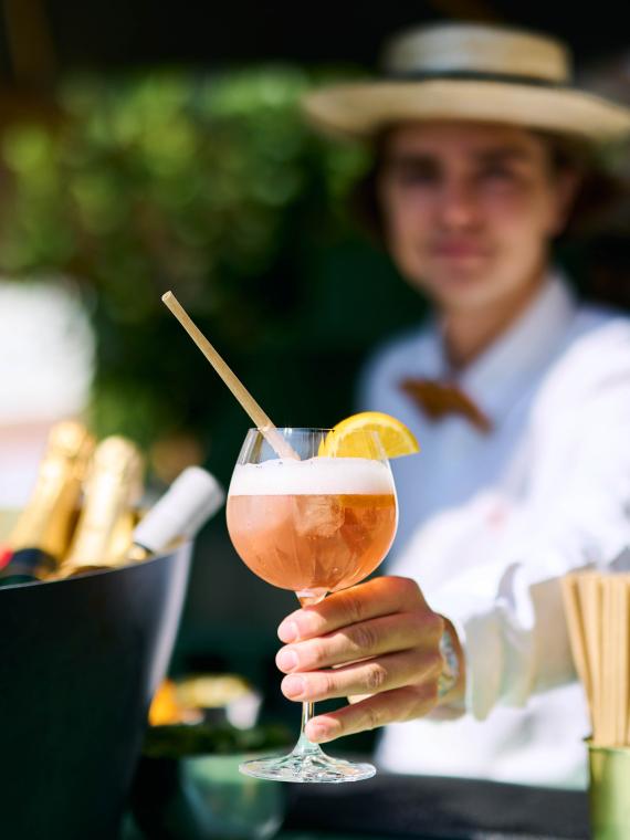 Cocktail fruité servi par un hôte dans l'espace Mezzanine de Roland-Garros