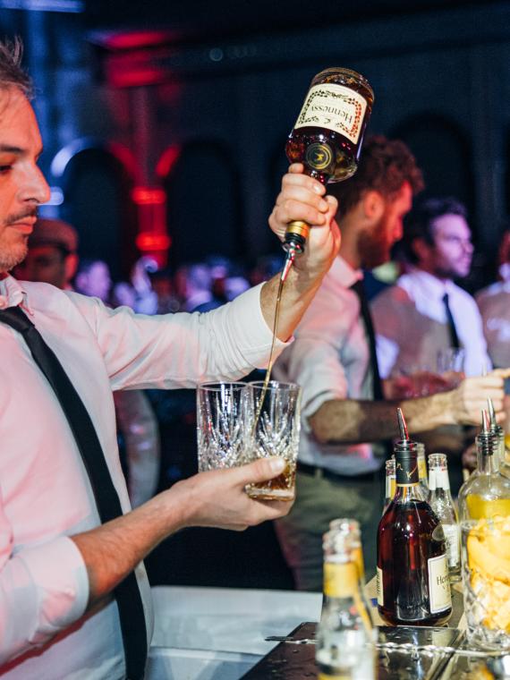 Barman pooring a drink in hospitality area