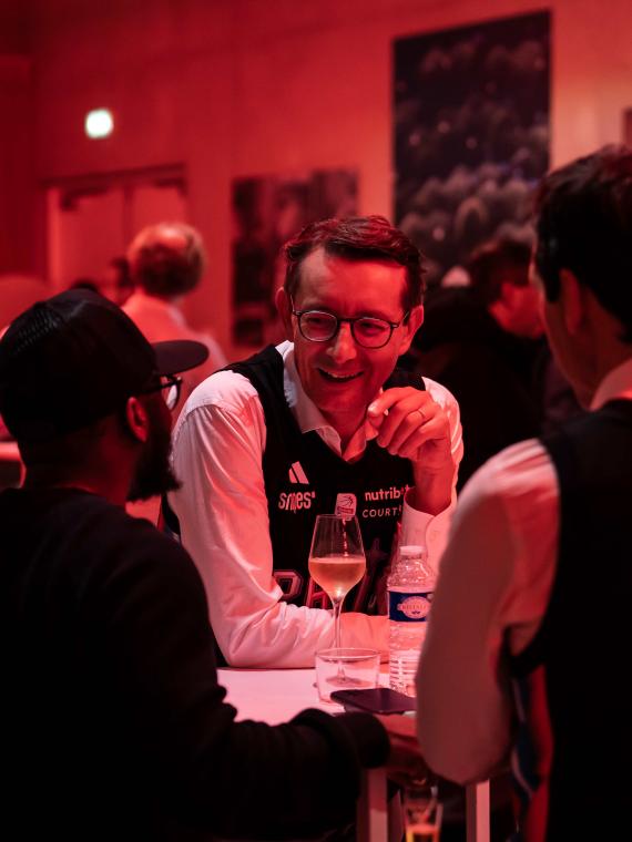 Guests enjoying the hospitality lounge at the Courtside Club in the Adidas Arena, exchanging experiences during a Paris Basketball game