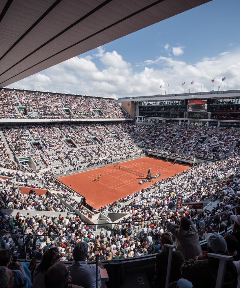 Public qui applaudit pendant un match Roland Garros sur terrain en terre battue